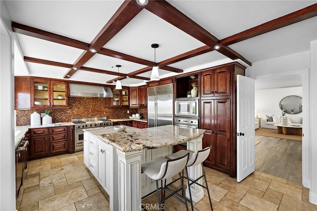 609 Calle Reata, San Clemente, CA 92673 - kitchen with built in appliances, stone tile flooring, wall chimney exhaust hood, a kitchen island, and tasteful backsplash