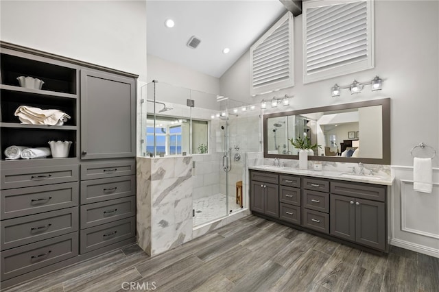 609 Calle Reata, San Clemente, CA 92673 - bathroom featuring double vanity, a shower stall, vaulted ceiling, and wood finished floors