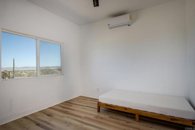 5655 Last Mile Rd, Johnson Valley, CA 92285 - empty room with a wall unit AC and light wood-style flooring
