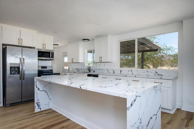 5655 Last Mile Rd, Johnson Valley, CA 92285 - kitchen with appliances with stainless steel finishes, white cabinetry, a center island, light stone countertops, and light wood-style floors