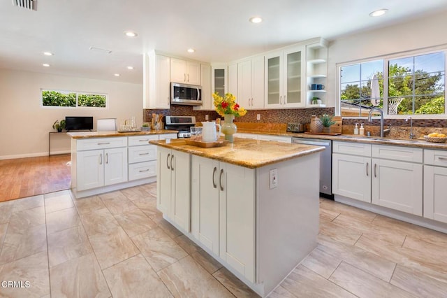 2767 Brookhill St, La Crescenta, CA 91214 - kitchen with appliances with stainless steel finishes, a kitchen island, backsplash, light stone counters, and recessed lighting