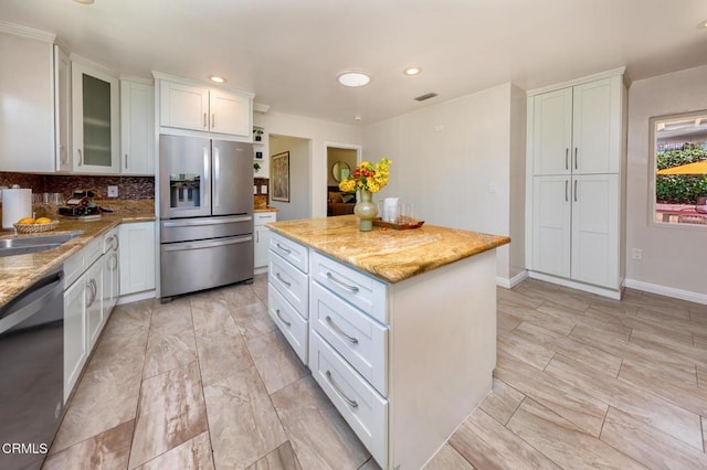 2767 Brookhill St, La Crescenta, CA 91214 - kitchen featuring appliances with stainless steel finishes, white cabinetry, a kitchen island, light stone counters, and glass insert cabinets