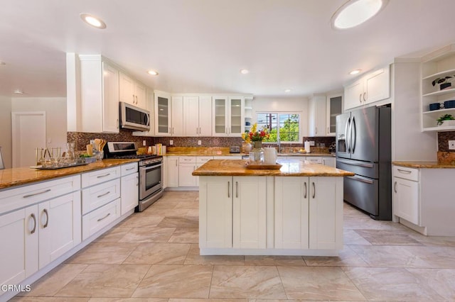 2767 Brookhill St, La Crescenta, CA 91214 - kitchen featuring stainless steel appliances, light stone counters, white cabinetry, decorative backsplash, and recessed lighting