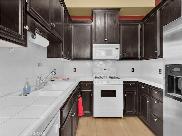 5242 Vesper Ave Unit 7, Sherman Oaks, CA 91411 - kitchen with white appliances, decorative backsplash, dark brown cabinetry, and tile counters
