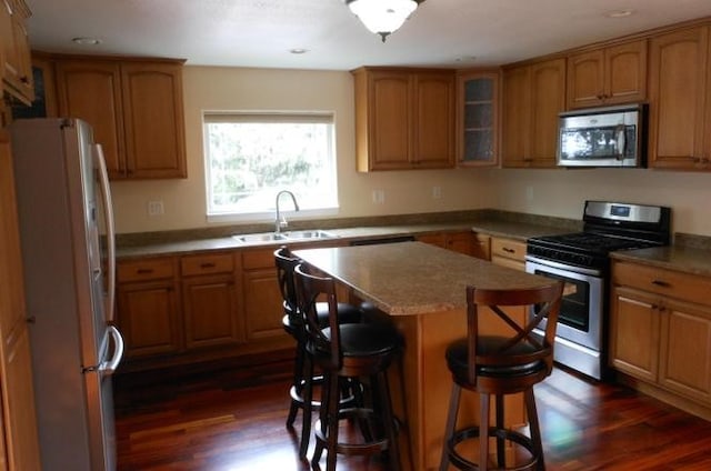 1020 Alpha St, Eureka, CA 95503 - kitchen featuring appliances with stainless steel finishes, brown cabinetry, dark wood finished floors, a breakfast bar, and recessed lighting