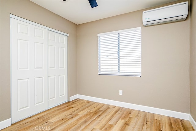 73570 Cedar Dr Unit 29, Palms, CA 92277 - unfurnished bedroom with a wall mounted AC, a closet, wood finished floors, and a ceiling fan