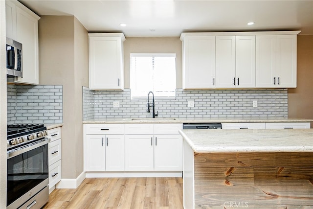 73570 Cedar Dr Unit 29, Palms, CA 92277 - kitchen with stainless steel appliances, white cabinetry, tasteful backsplash, light wood-type flooring, and recessed lighting