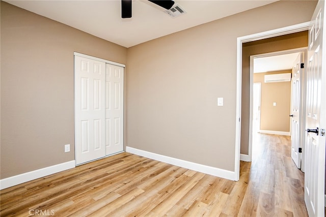 73570 Cedar Dr Unit 29, Palms, CA 92277 - unfurnished bedroom with a wall unit AC, light wood-style floors, a closet, and ceiling fan