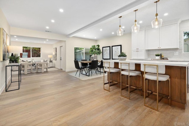 5461 Waring Rd, San Diego, CA 92120 - kitchen featuring recessed lighting, light wood-style floors, light countertops, white cabinetry, and a kitchen bar
