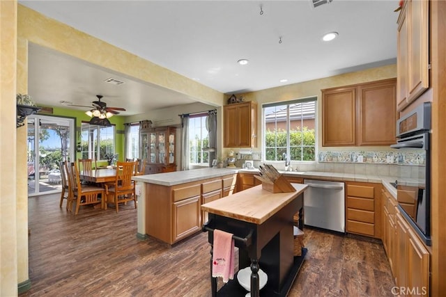 10705 Topiary Dr, Bakersfield, CA 93306 - kitchen with dishwasher, oven, a peninsula, dark wood-style floors, and recessed lighting