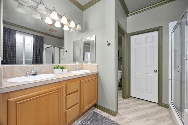 10705 Topiary Dr, Bakersfield, CA 93306 - full bath with crown molding, a shower stall, double vanity, wood finished floors, and decorative backsplash