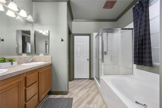 10705 Topiary Dr, Bakersfield, CA 93306 - full bathroom with a stall shower, ornamental molding, a bath, double vanity, and wood finished floors