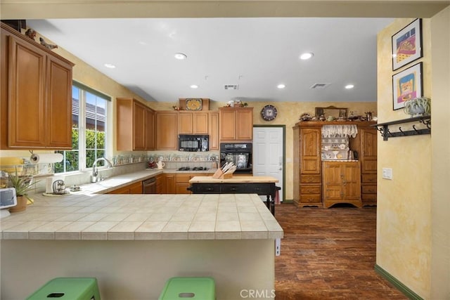 10705 Topiary Dr, Bakersfield, CA 93306 - kitchen featuring black appliances, a peninsula, dark wood-style floors, recessed lighting, and backsplash
