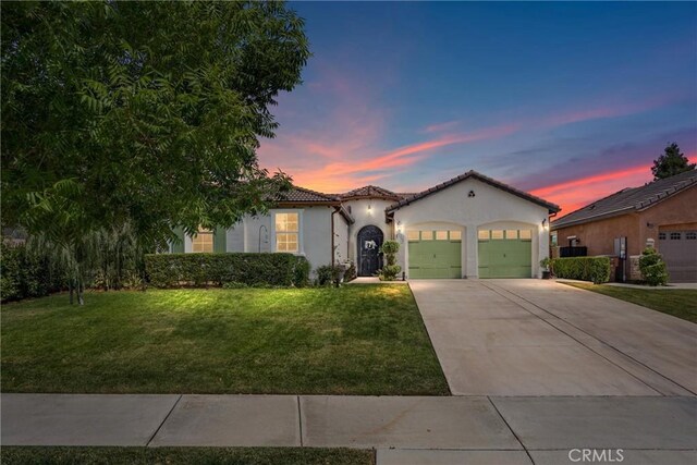 10705 Topiary Dr, Bakersfield, CA 93306 - mediterranean / spanish house featuring stucco siding, an attached garage, a yard, a tiled roof, and concrete driveway