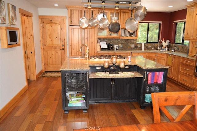 38800 Fawn Point Ln, Bass Lake, CA 93604 - kitchen featuring decorative backsplash, stainless steel gas cooktop, dark wood-type flooring, recessed lighting, and a center island with sink