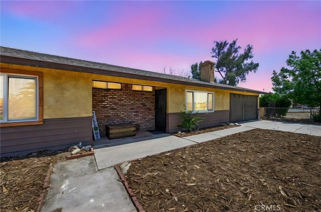 27636 Ethanac Rd, Menifee, CA 92585 - view of front facade featuring an attached garage, driveway, a chimney, and stucco siding