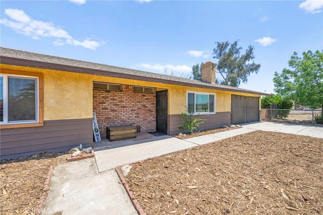 27636 Ethanac Rd, Menifee, CA 92585 - view of front of property featuring a garage, concrete driveway, a chimney, stucco siding, and brick siding