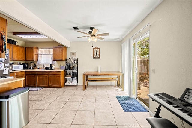27636 Ethanac Rd, Menifee, CA 92585 - kitchen with white microwave, brown cabinetry, plenty of natural light, and light countertops