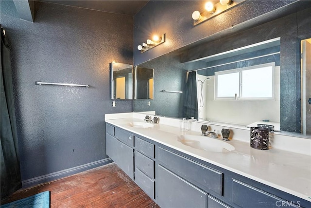 13905 Caspian Way, Moreno Valley, CA 92553 - bathroom featuring wood finished floors, double vanity, a shower with shower curtain, and a textured wall