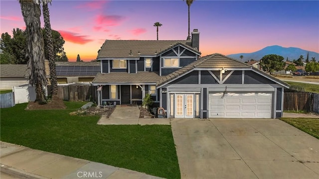 13905 Caspian Way, Moreno Valley, CA 92553 - view of front of home with french doors, a chimney, a tile roof, concrete driveway, and a garage