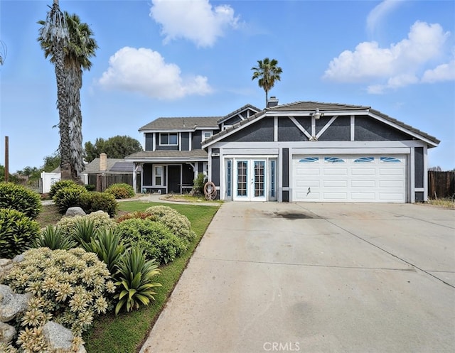 13905 Caspian Way, Moreno Valley, CA 92553 - view of front facade featuring french doors, an attached garage, driveway, stucco siding, and a chimney