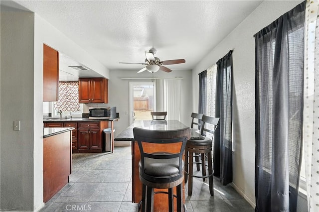 13905 Caspian Way, Moreno Valley, CA 92553 - dining area with ceiling fan, tile patterned flooring, and a textured ceiling
