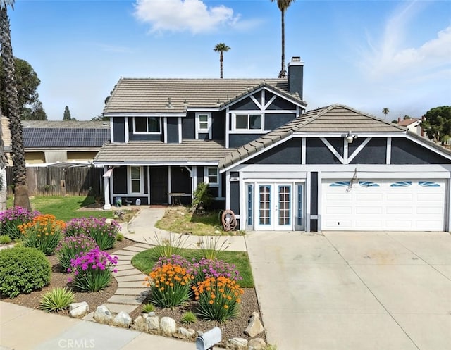 13905 Caspian Way, Moreno Valley, CA 92553 - rear view of property featuring a tiled roof, a chimney, french doors, an attached garage, and driveway