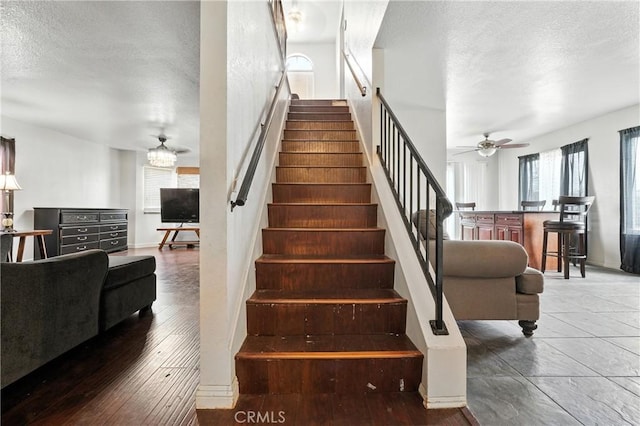 13905 Caspian Way, Moreno Valley, CA 92553 - staircase featuring ceiling fan, a textured ceiling, plenty of natural light, and wood-type flooring