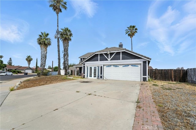 13905 Caspian Way, Moreno Valley, CA 92553 - view of front of property featuring french doors, driveway, a chimney, and an attached garage