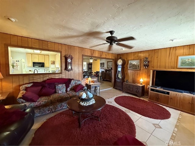 59663 Sunway Dr, Yucca Valley, CA 92284 - tiled living area with wood walls, a ceiling fan, and a textured ceiling