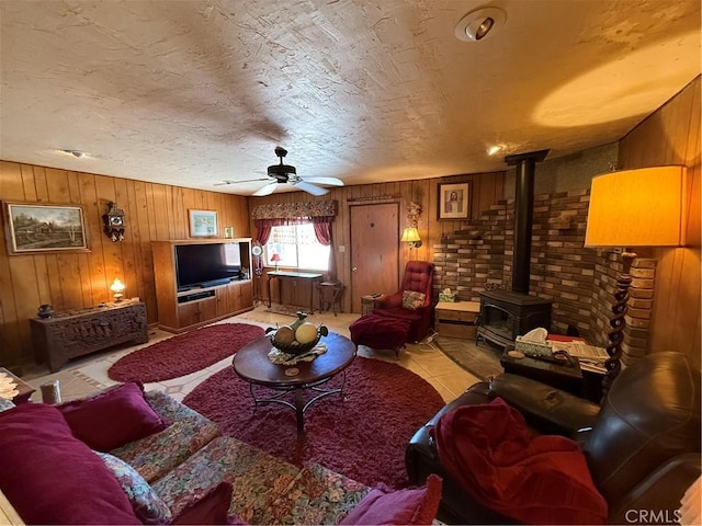 59663 Sunway Dr, Yucca Valley, CA 92284 - living area featuring a wood stove, wooden walls, and a ceiling fan