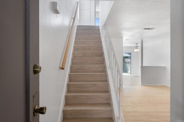 3418 Seabreeze Walk, Oceanside, CA 92056 - stairway featuring a ceiling fan, wood finished floors, and a textured ceiling