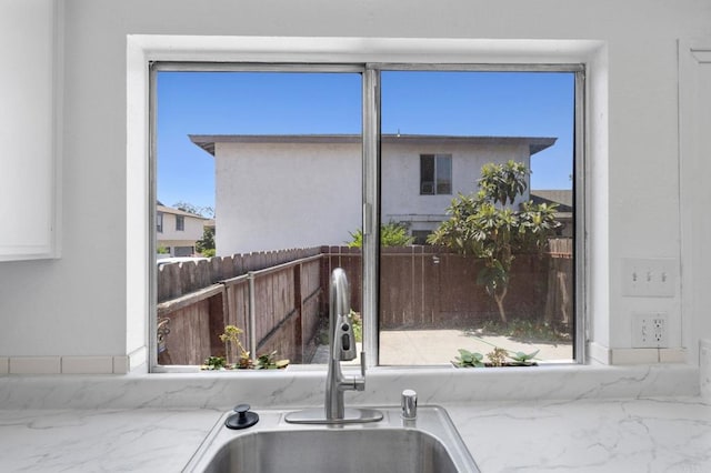 3418 Seabreeze Walk, Oceanside, CA 92056 - kitchen featuring marble finish floors, light stone counters, and white cabinetry