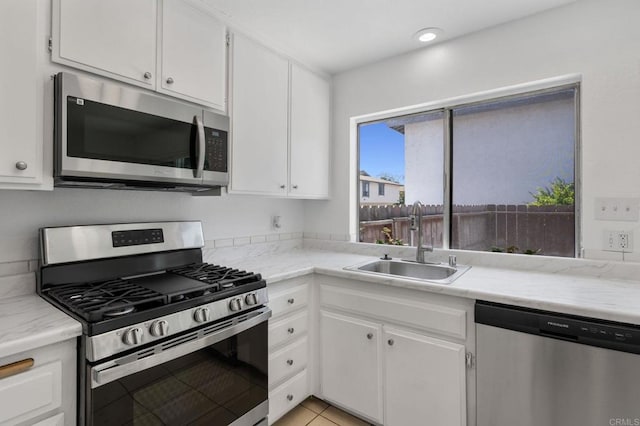 3418 Seabreeze Walk, Oceanside, CA 92056 - kitchen with stainless steel appliances, white cabinetry, and light tile patterned floors