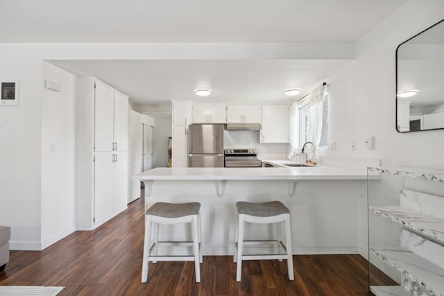 155 Rosebay Dr Unit 31, Encinitas, CA 92024 - kitchen featuring stainless steel appliances, a peninsula, dark wood-type flooring, light countertops, and white cabinets