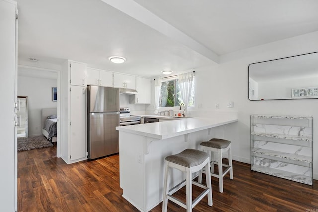 155 Rosebay Dr Unit 31, Encinitas, CA 92024 - kitchen featuring stainless steel appliances, a peninsula, dark wood-style floors, and a breakfast bar