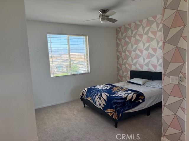 16009 Pitzer St, Fontana, CA 92336 - carpeted bedroom with an accent wall and a ceiling fan