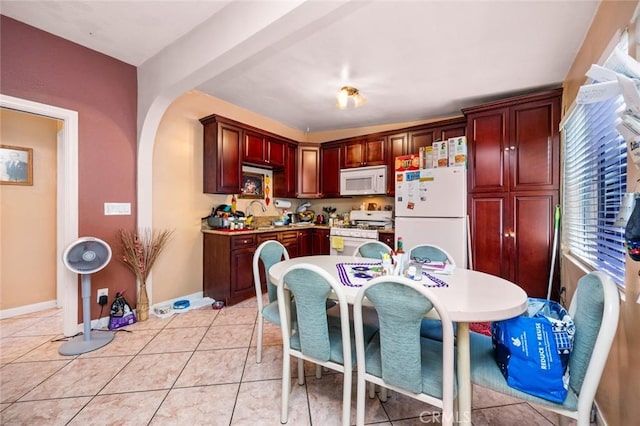 1258 N Ditman Ave, Los Angeles, CA 90063 - kitchen featuring white appliances, reddish brown cabinets, arched walkways, light tile patterned flooring, and light countertops