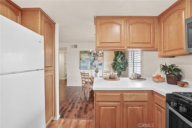 4809 Fieldbrook Ln, Cypress, CA 90630 - kitchen featuring freestanding refrigerator, a peninsula, wood finished floors, light countertops, and a chandelier