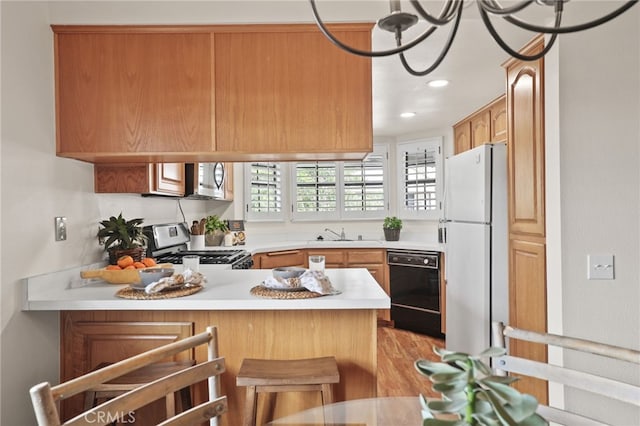 4809 Fieldbrook Ln, Cypress, CA 90630 - kitchen featuring appliances with stainless steel finishes, light countertops, a peninsula, recessed lighting, and light wood-type flooring