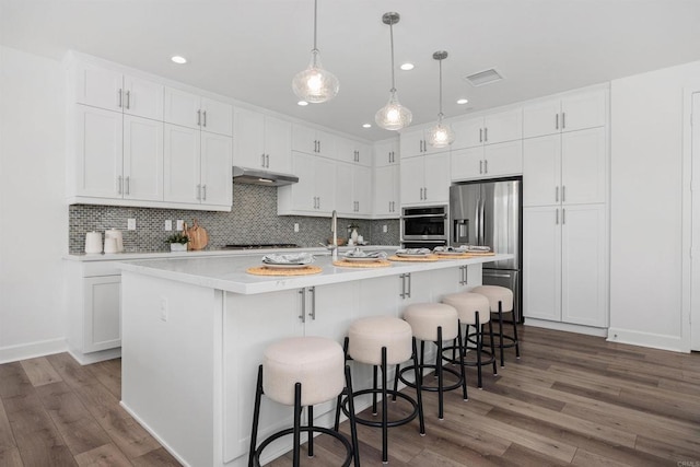 3002 Villeta Ave, Carlsbad, CA 92010 - kitchen featuring appliances with stainless steel finishes, under cabinet range hood, decorative backsplash, white cabinets, and recessed lighting