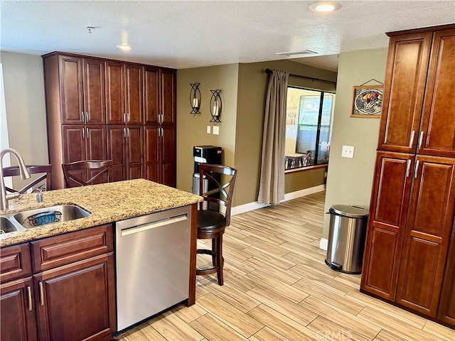 9150 Boxwood Ave, Fontana, CA 92335 - kitchen featuring stainless steel dishwasher, light wood-type flooring, a textured ceiling, light stone counters, and recessed lighting