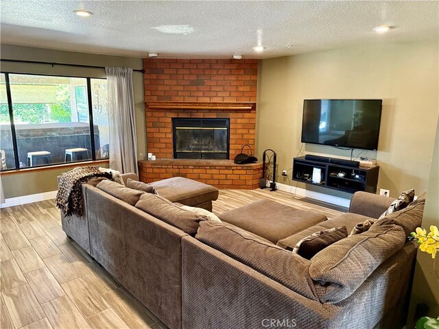 9150 Boxwood Ave, Fontana, CA 92335 - living room with a textured ceiling, a fireplace, wood finished floors, and recessed lighting