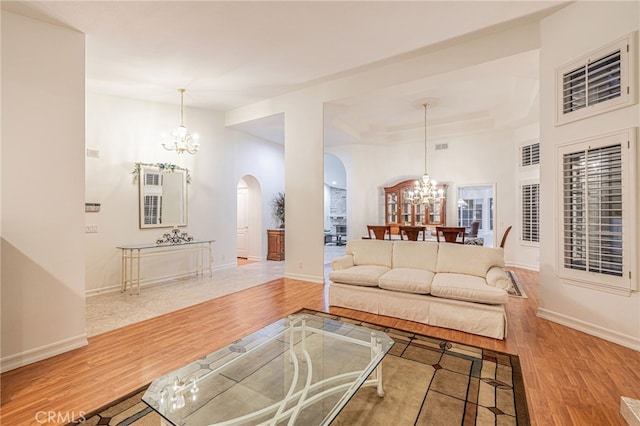 19809 Winged Foot Way, Porter Ranch, CA 91326 - living room featuring a chandelier, arched walkways, and wood finished floors