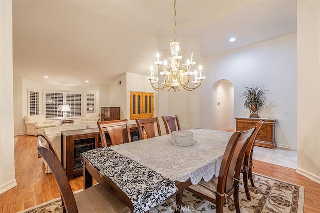 19809 Winged Foot Way, Porter Ranch, CA 91326 - dining space with arched walkways, light wood-style floors, a chandelier, and recessed lighting