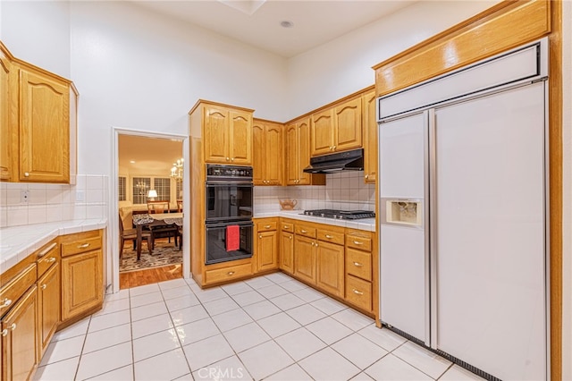 19809 Winged Foot Way, Porter Ranch, CA 91326 - kitchen featuring paneled fridge, tile countertops, backsplash, under cabinet range hood, and stainless steel gas cooktop