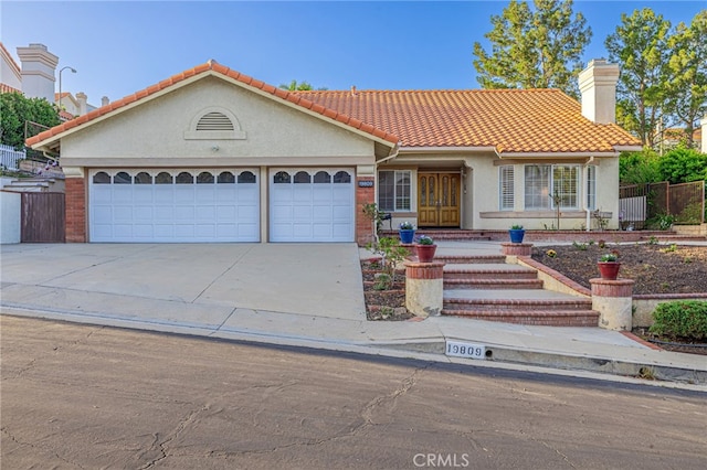 19809 Winged Foot Way, Porter Ranch, CA 91326 - view of front of property featuring concrete driveway, an attached garage, a chimney, stucco siding, and a tiled roof