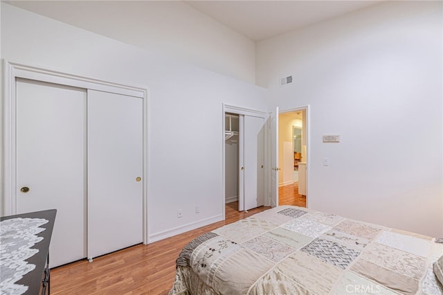 19809 Winged Foot Way, Porter Ranch, CA 91326 - bedroom with two closets, light wood-type flooring, and a high ceiling