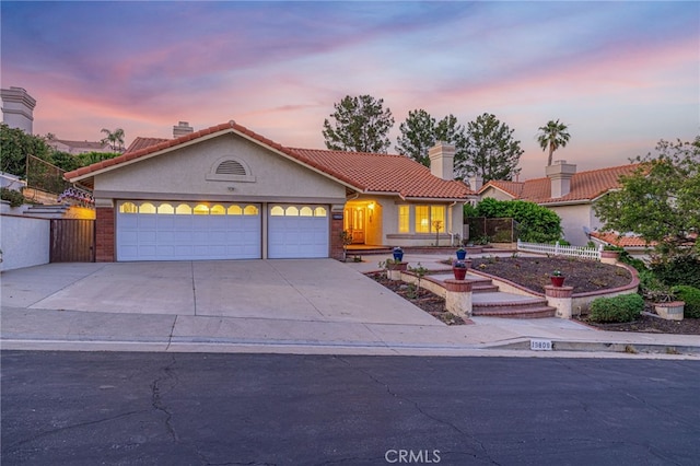 19809 Winged Foot Way, Porter Ranch, CA 91326 - view of front of home featuring a chimney, concrete driveway, stucco siding, and a tile roof