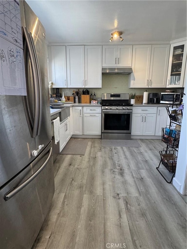 300 N Isabel St Unit 21, Glendale, CA 91206 - kitchen featuring stainless steel appliances, under cabinet range hood, white cabinets, and light wood-type flooring